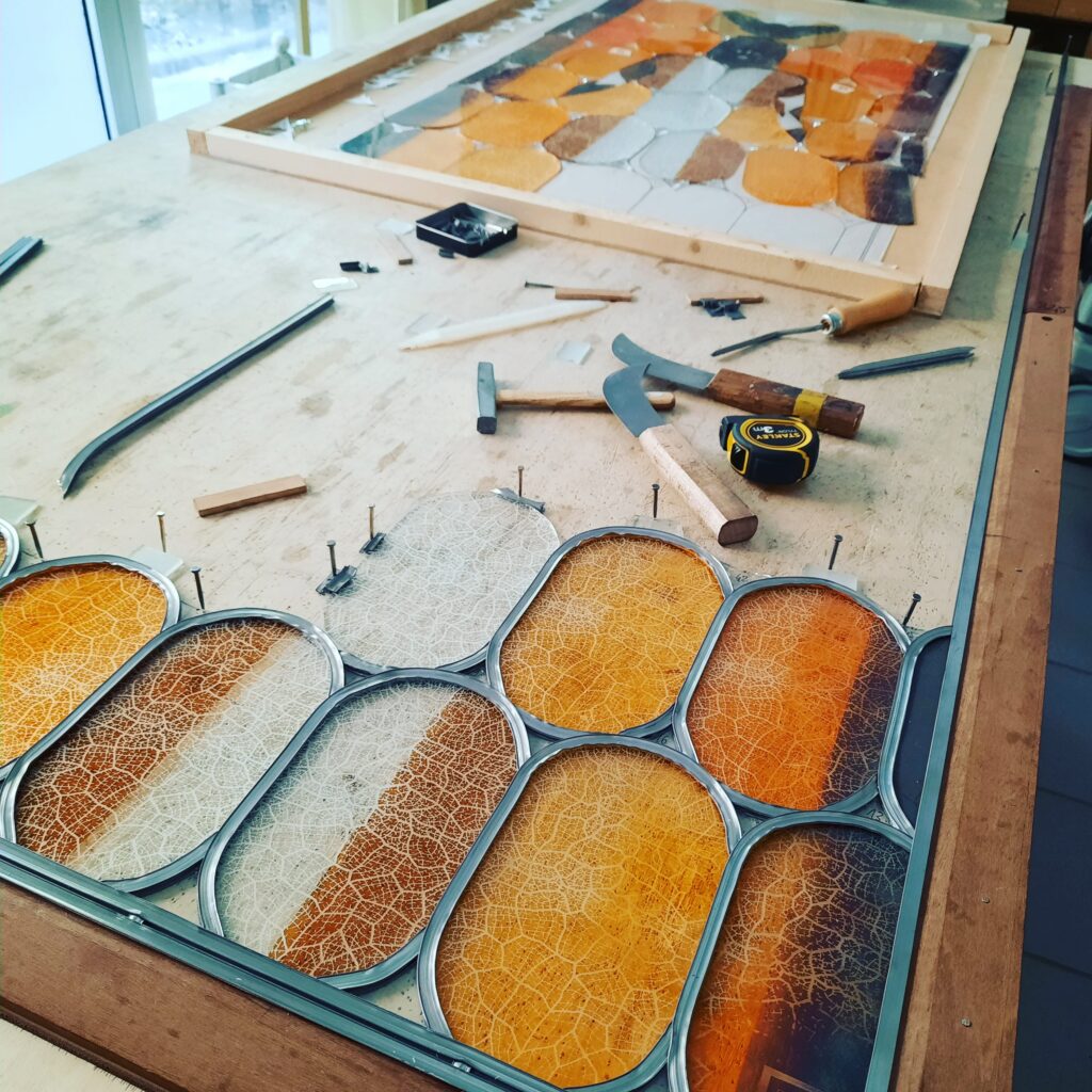 dans atelier table de montage d'un vitrail avec verre couteau plomb outils