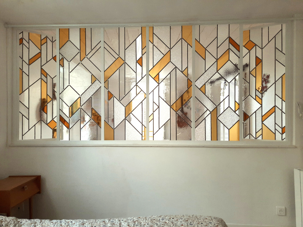 vitraux contemporains dans les tons jaunes et ambrés dans verrière en métal création fab luz vitrail